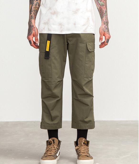 mens wearing camouflage jogger pants with elastic waist and side buttons, styled for a casual streetwear look.