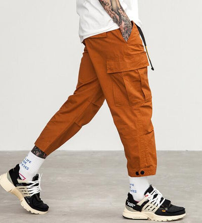 mens wearing camouflage jogger pants with elastic waist and side buttons, styled for a casual streetwear look.