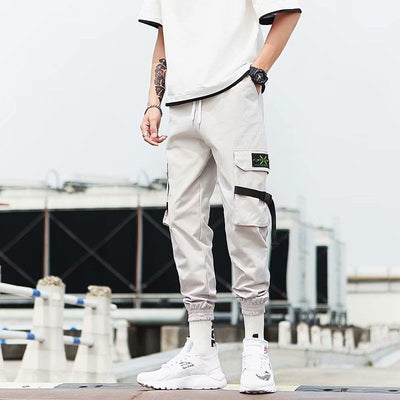 Hip Hop jogger pants in light gray with cargo pockets, styled with a casual white t-shirt and sporty footwear.