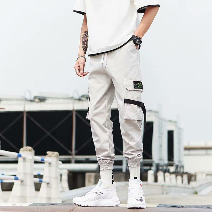 Hip Hop jogger pants in light gray with cargo pockets, styled with a casual white t-shirt and sporty footwear.