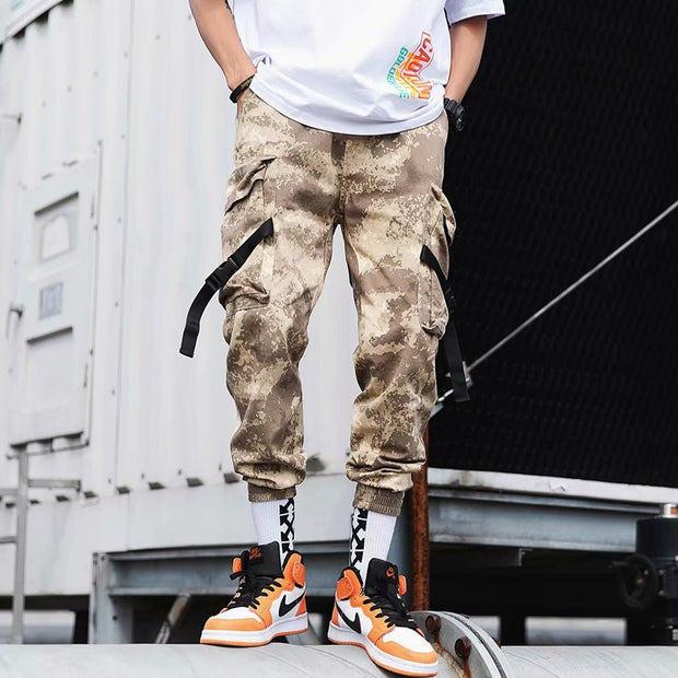 Stylish hip hop jogger pants in camo pattern, featuring cargo pockets and paired with trendy sneakers.