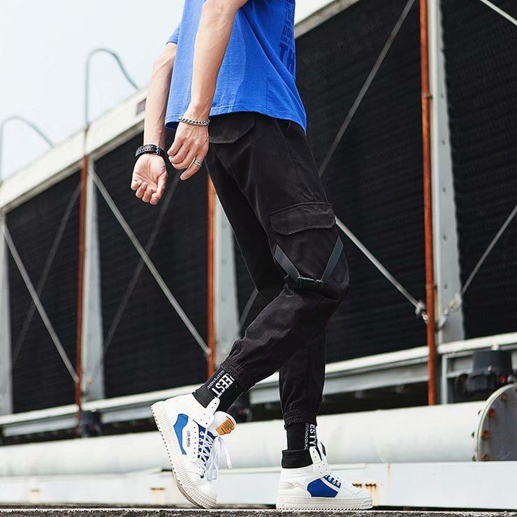 Stylish hip hop jogger pants in black, paired with a blue shirt and trendy sneakers, perfect for casual wear.